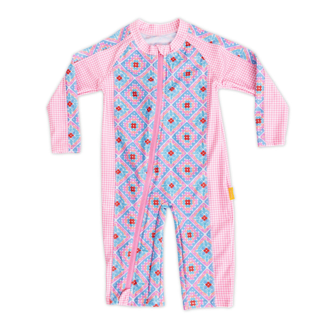 Baby long sleeve sunsuit in Petal Patchwork crochet print with pink gingham panels, full-length sleeves and legs, UPF 50+ sun protection, front zip closure, made from recycled polyester swim fabric.