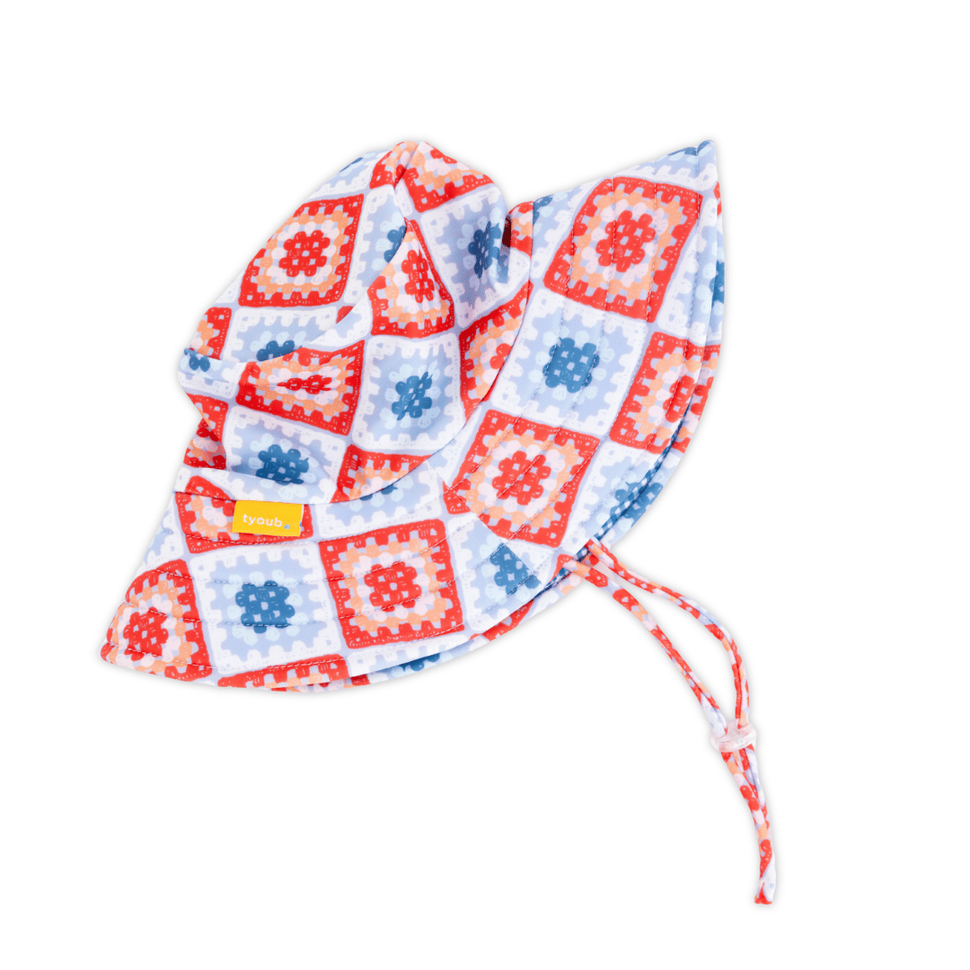 Side view of Tyoub kids’ wide brim bucket hat in Modern Retro Granny Square design, foam shape-retention brim for face and neck coverage, adjustable chin strap with clear toggle quick release clip closure, eco-friendly recycled swim fabric. 