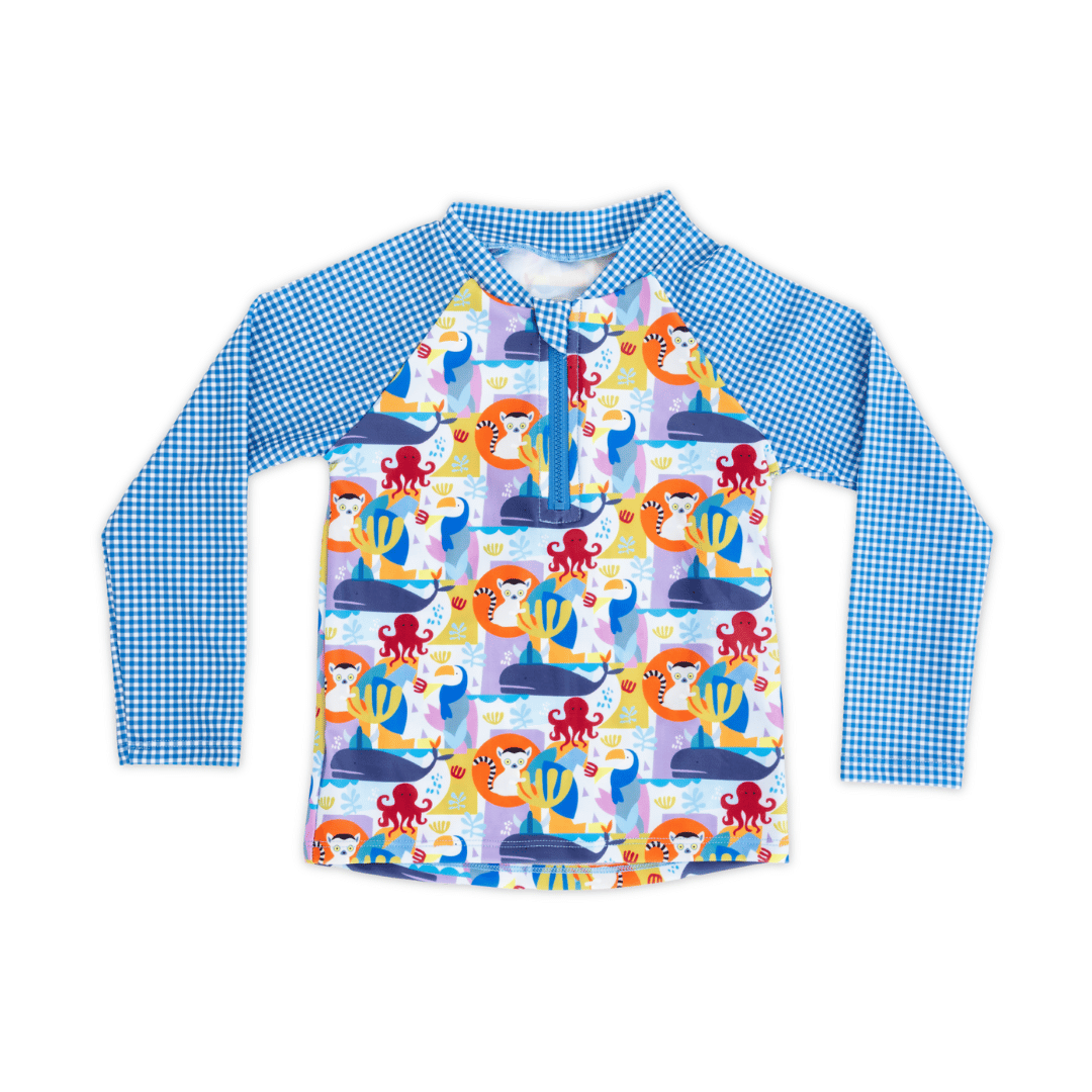 Unisex kids’ long sleeve rash guard with high neckline, Animal Spirit print featuring lemur, toucan, whale and octopus, blue gingham raglan sleeves, UPF 50+ sun protection, eco-friendly recycled polyester swim fabric.